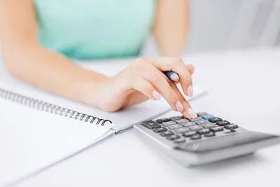 woman using a calculator to calculate her finances